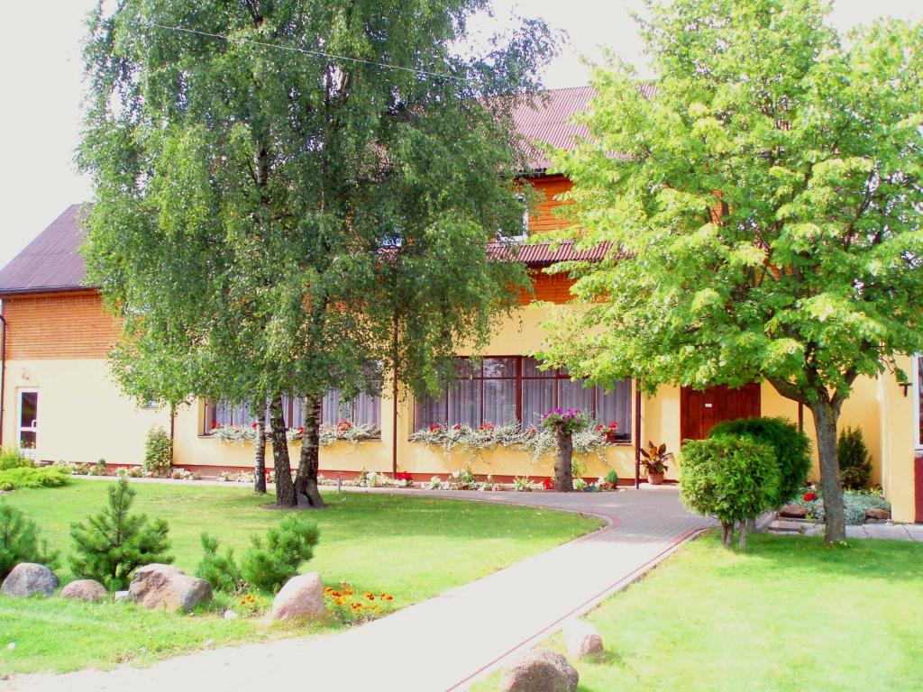 a building with trees and a path in front of it at Buožinta in Buožėnai