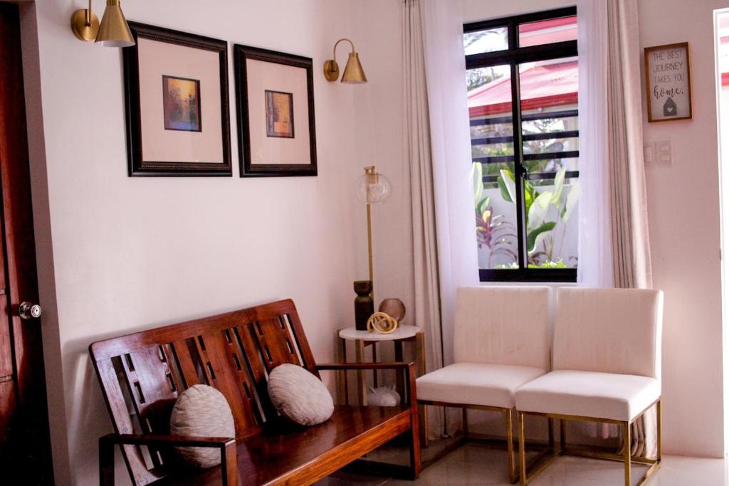 a living room with two chairs and a window at Secluded, Modern, Minimalist house - Gray House in Dampalan
