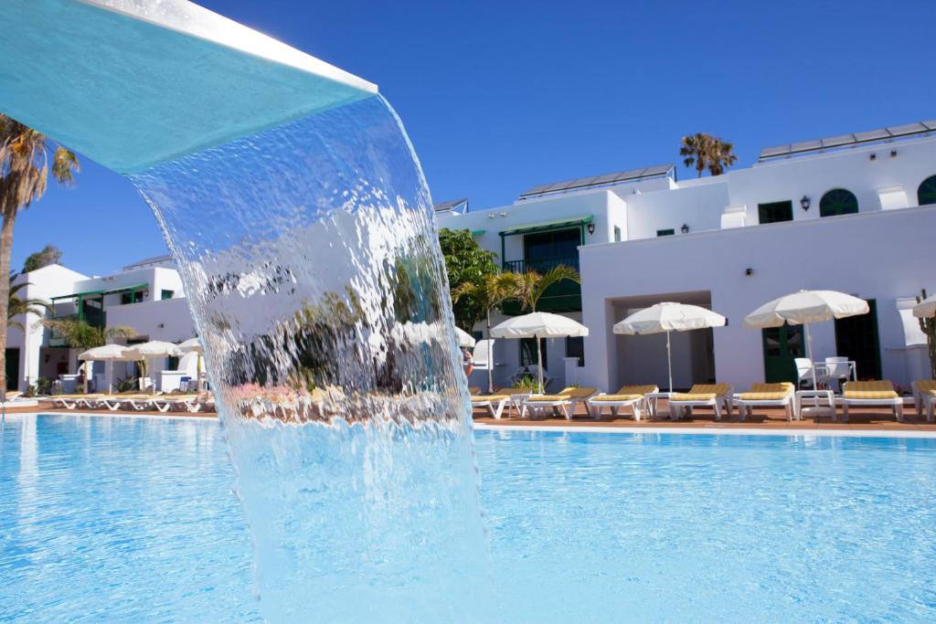 een fontein in het midden van een zwembad bij Gloria Izaro Club Hotel in Puerto del Carmen