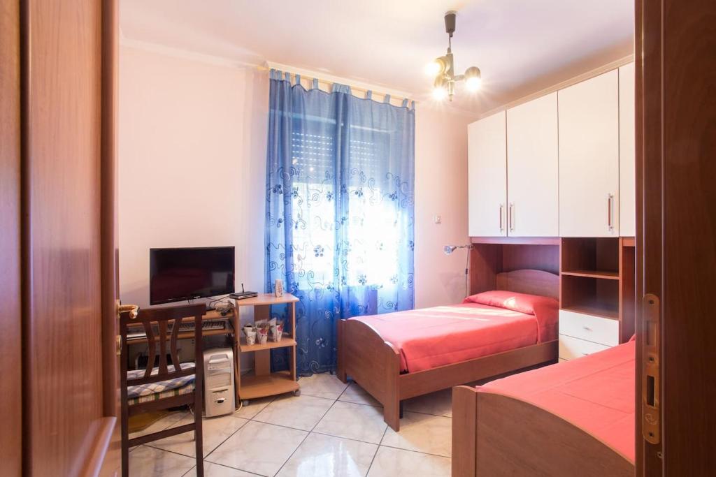 Dormitorio pequeño con cama y TV en Annie's Home, en La Giustiniana