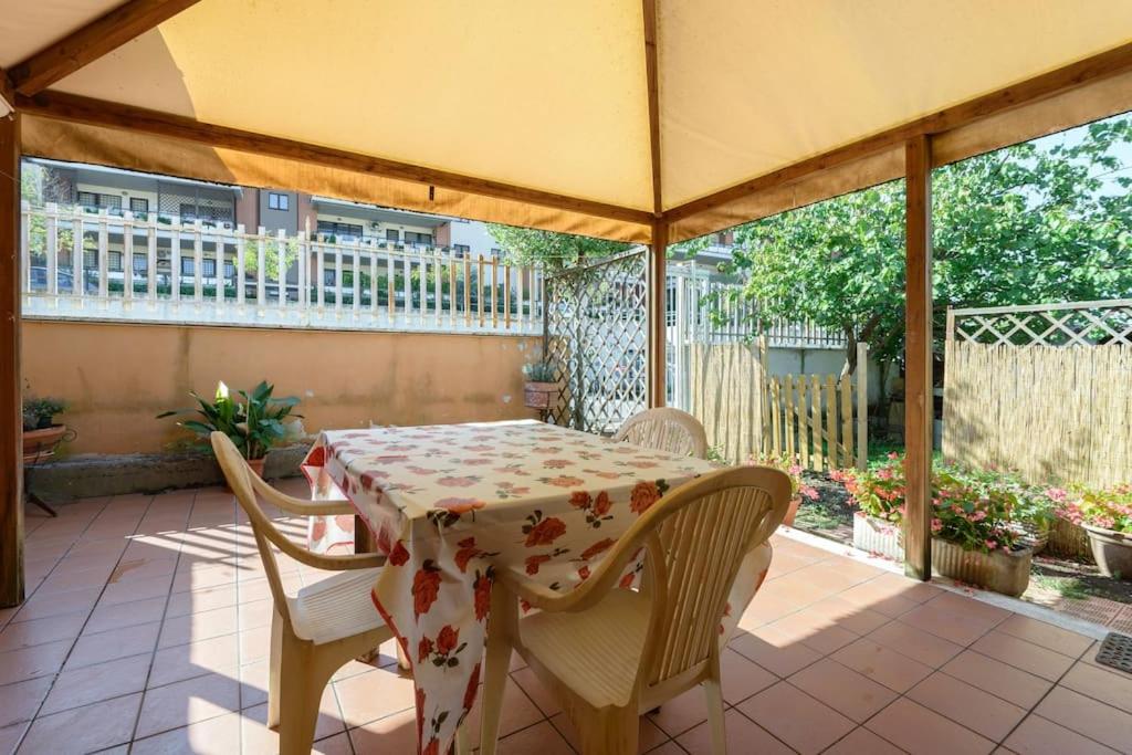 la casa di Anna... في Olgiata: طاولة وكراسي تحت مظلة على الفناء