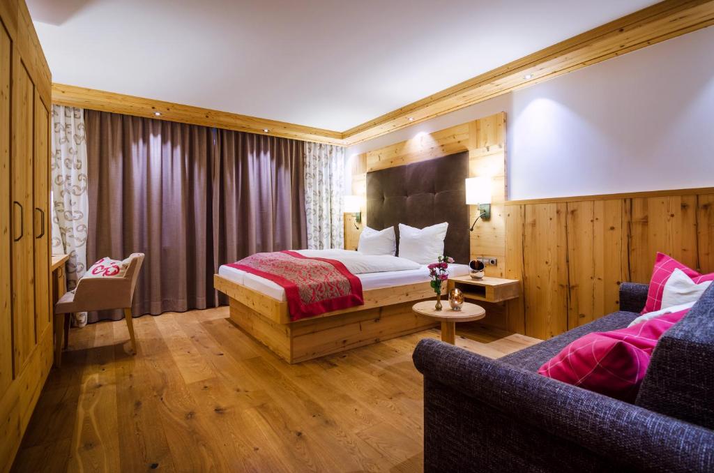 a hotel room with a bed and a couch at Hotel Central in Gerlos