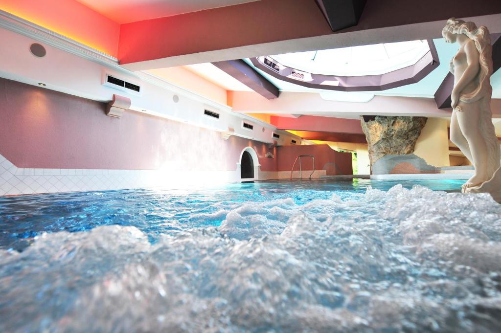 a woman standing in a pool of water in a room at Hotel Central in Gerlos
