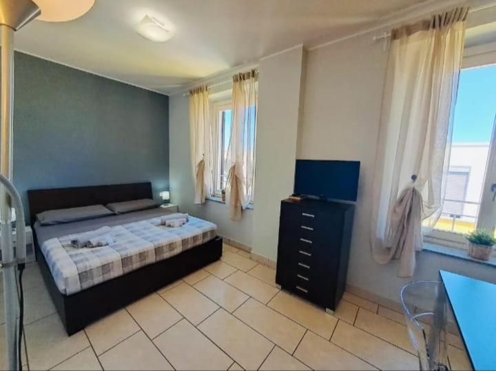 a bedroom with a bed and a dresser and windows at Appartamento Valentina in Cremona