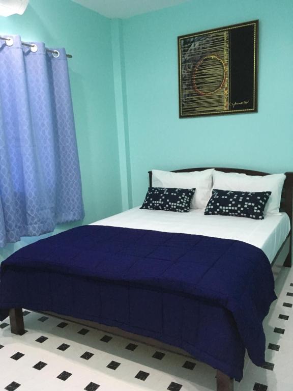 a blue bedroom with a bed with blue walls at Phuket Best Travel in Nai Yang Beach