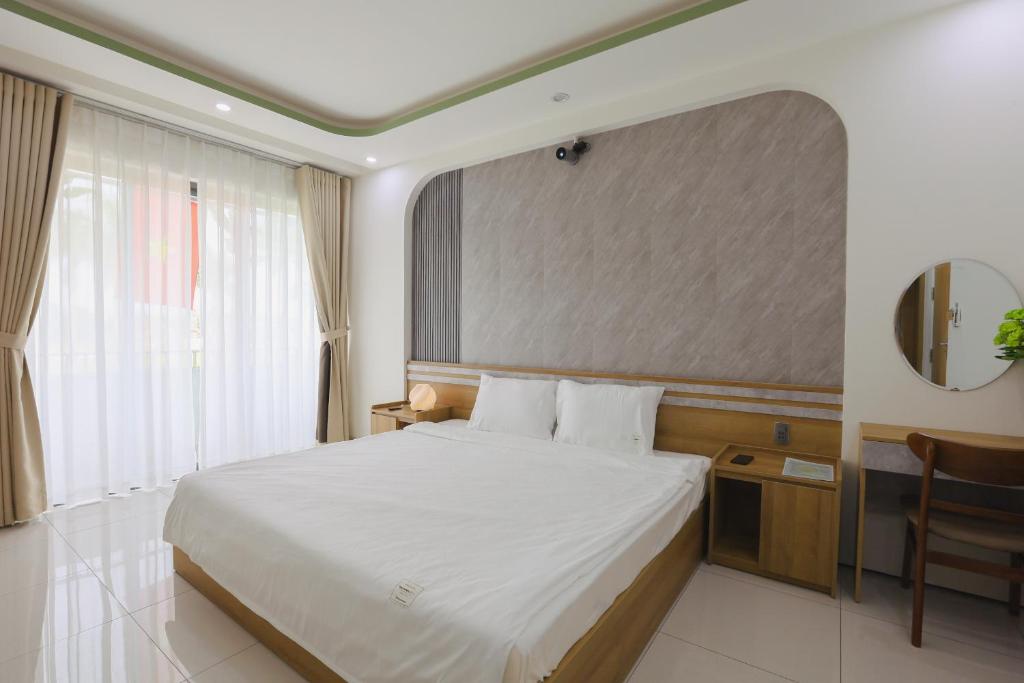 a hotel room with a bed and a mirror at Trà Homestay in Thôn Lại Thê