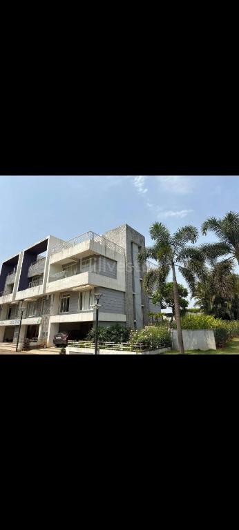 a large building with palm trees in front of it at Puranik sayama in Lonavala