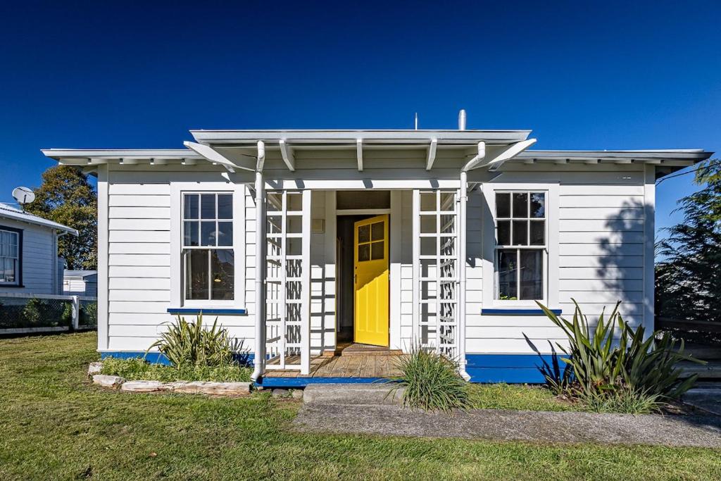 a small white tiny house with a yellow door at Ohakune's Yellow Door in Ohakune