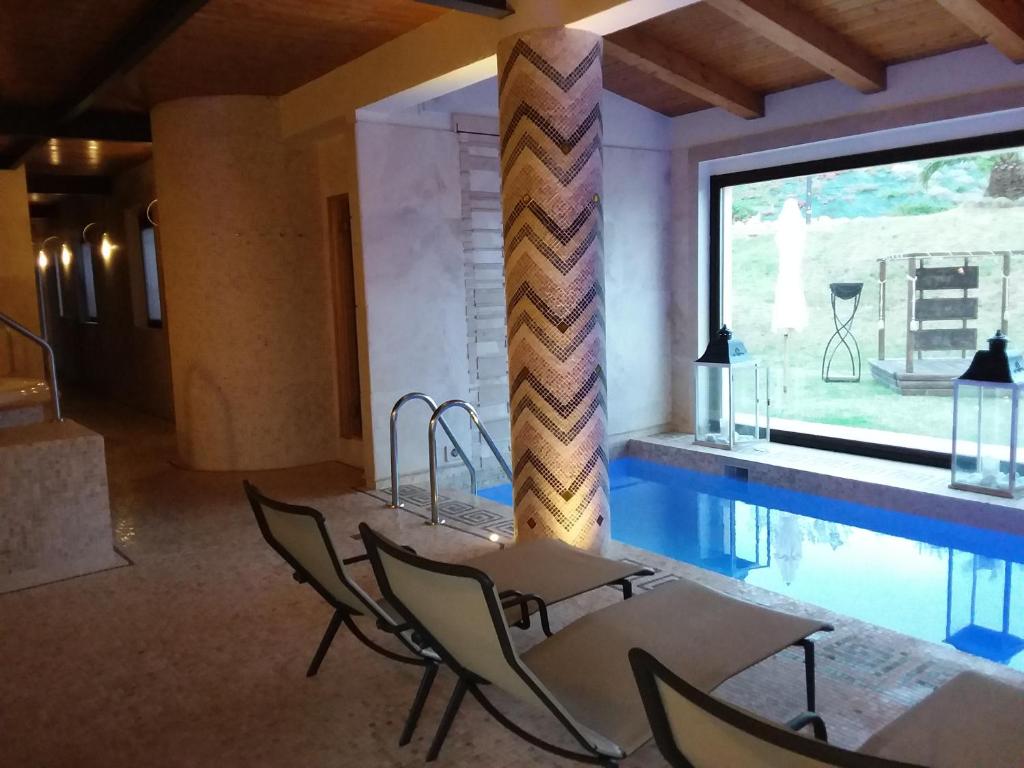 塞尼加利亞的住宿－Country House Martines Club Resort & Mandalay SPA，客房设有游泳池、椅子和桌子。