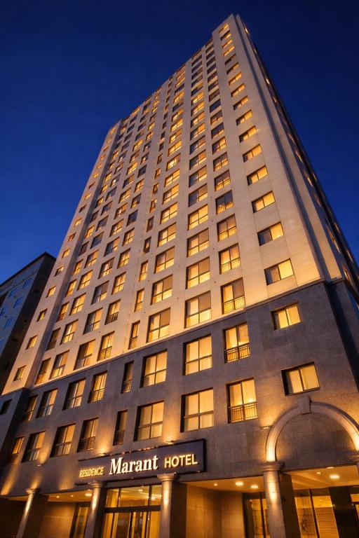 a large building with a mart hotel at night at Marant Residence Hotel Busan Station in Busan