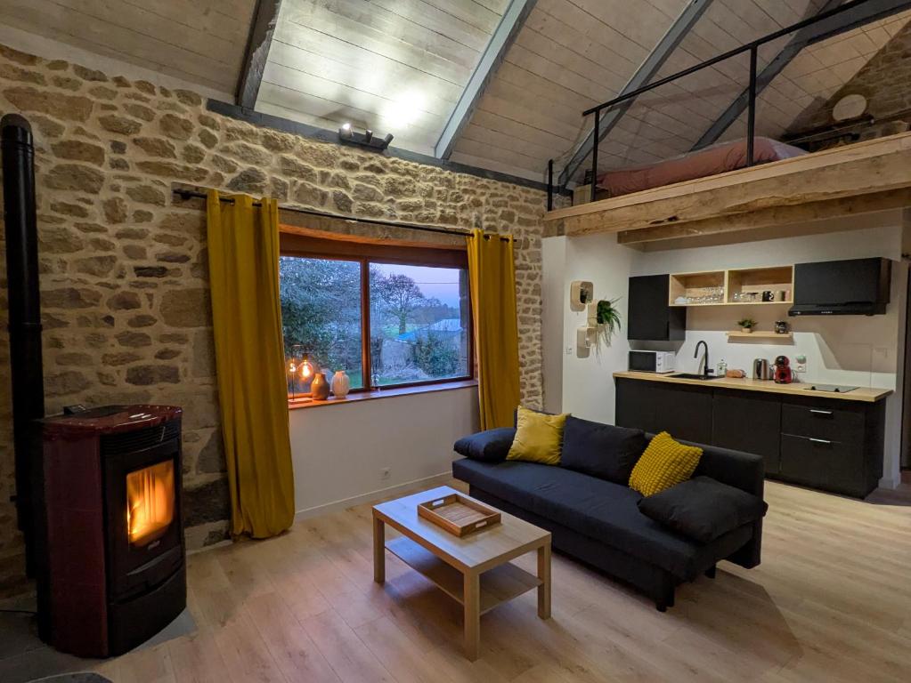 a living room with a couch and a fireplace at Gîte du Portz in Ploërdut