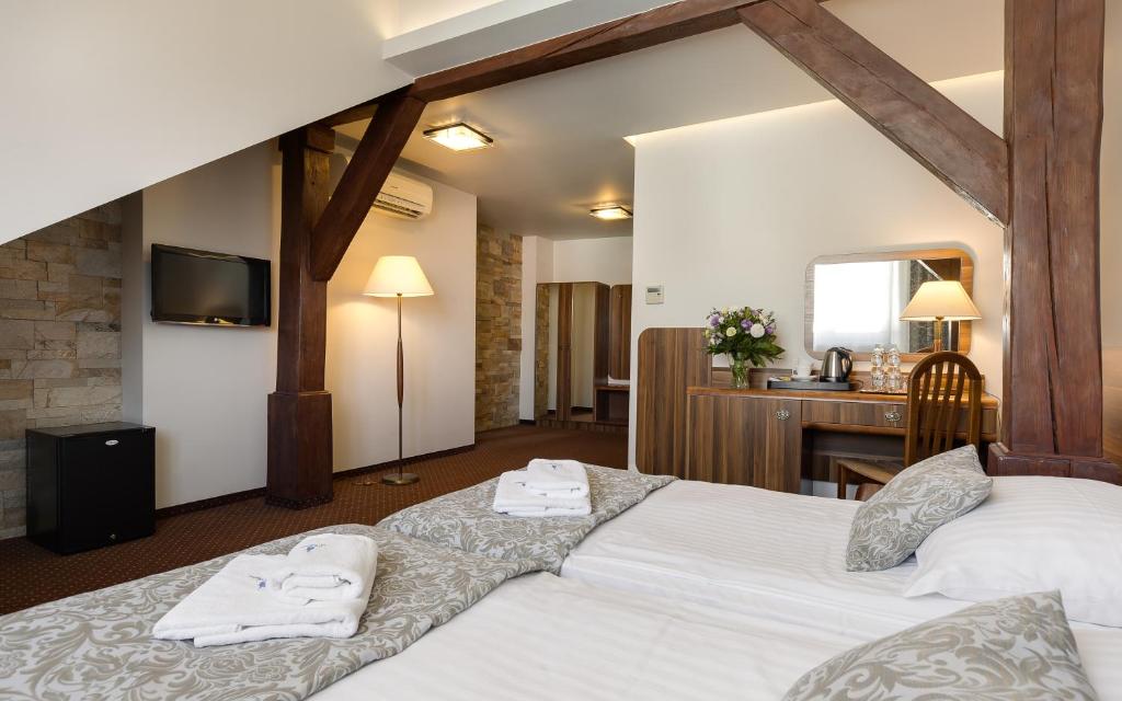 Habitación de hotel con 2 camas y escritorio en Hotel Wit Stwosz en Cracovia