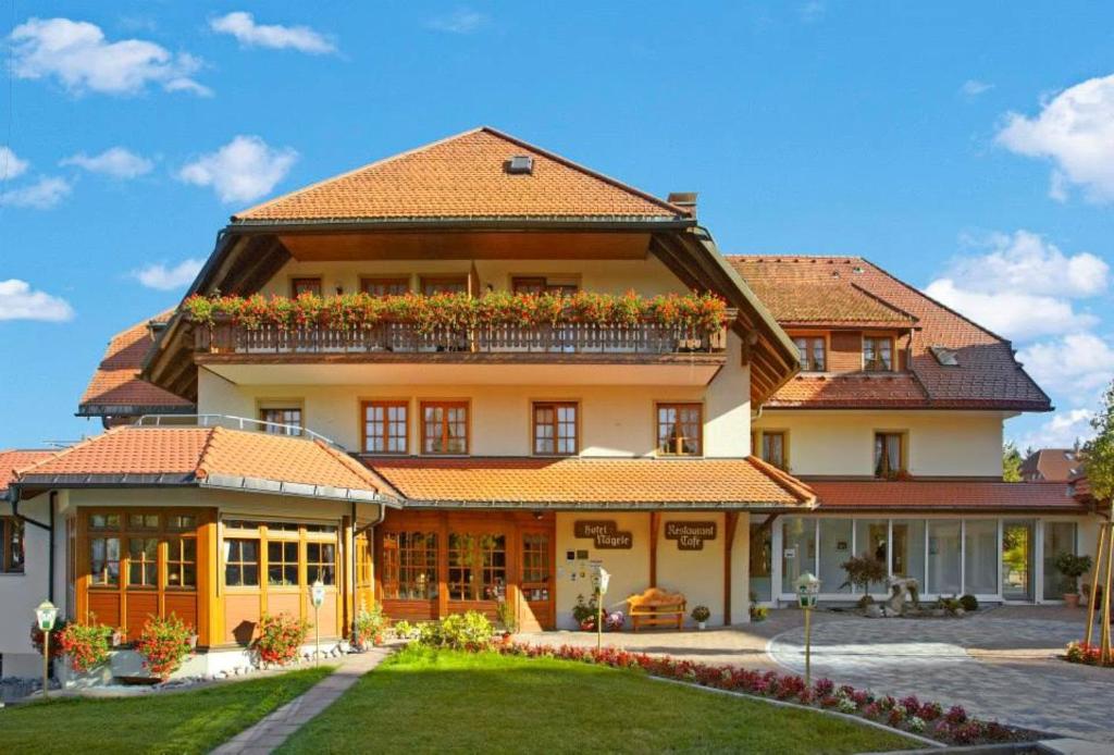 a large house with a balcony on top of it at Wander- & Wellnesshotel Nägele in Höchenschwand