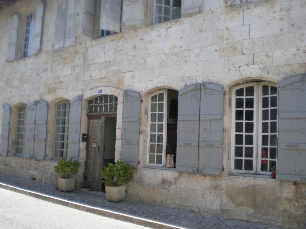 un edificio con ventanas y plantas delante de él en La Demeure Saint Clar, en Saint-Clar