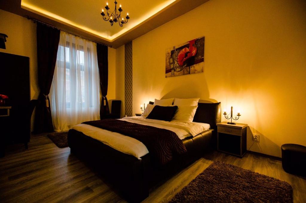 Schlafzimmer mit einem Bett und einem Kronleuchter in der Unterkunft Anna Central Studio in Sibiu