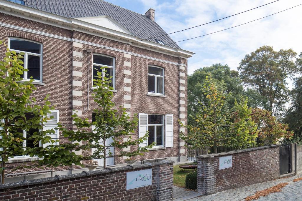 una casa di mattoni con alberi di fronte di De Oude Pastorij a Maarkedal