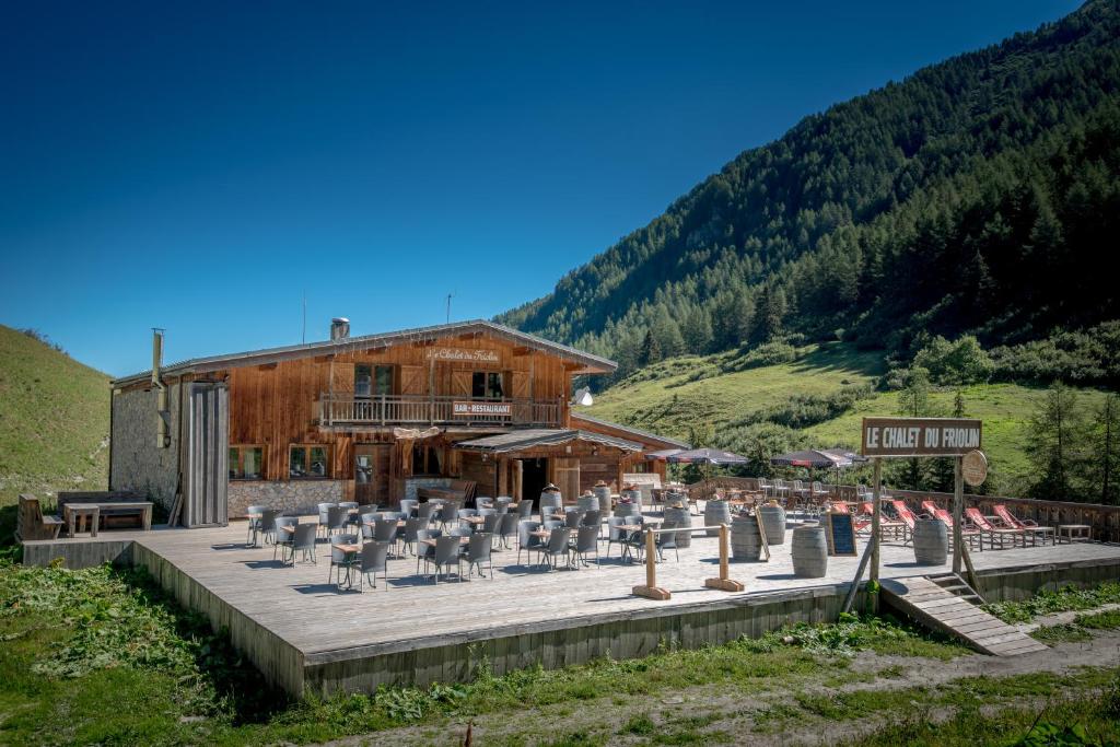 un bâtiment avec un groupe de chaises devant lui dans l'établissement Chalet Du Friolin, à Les Coches