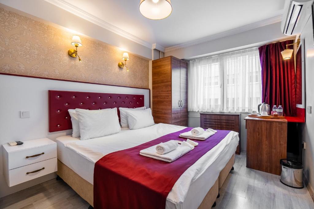 a bedroom with a large bed with towels on it at Cihangir Palace Hotel in Istanbul