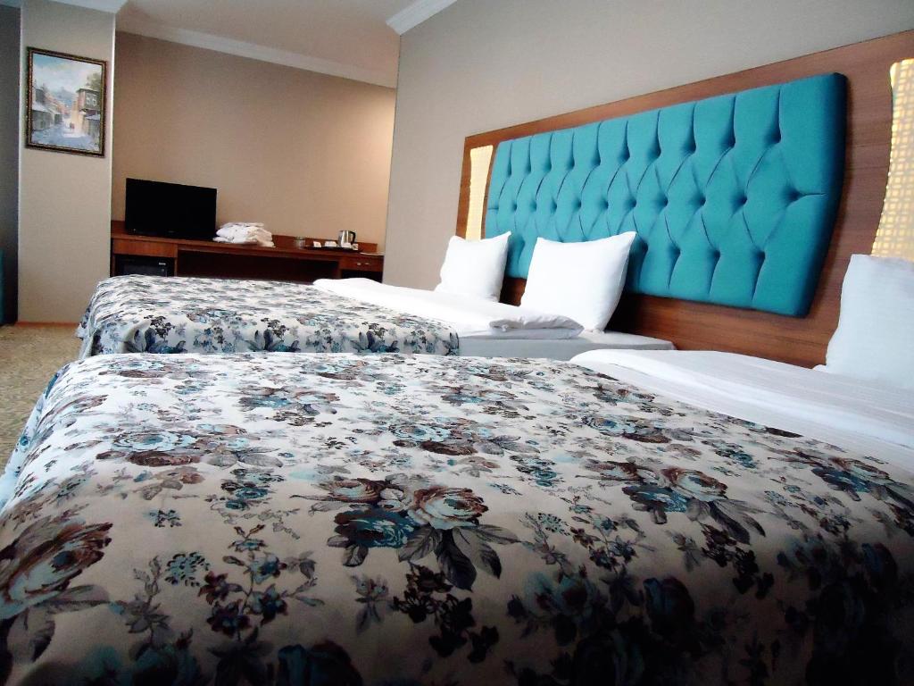 um quarto de hotel com duas camas e uma cabeceira azul em Golden Lounge Hotel em Istambul