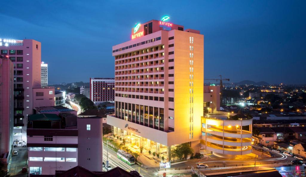un edificio illuminato in una città di notte di Bayview Hotel Melaka a Malacca