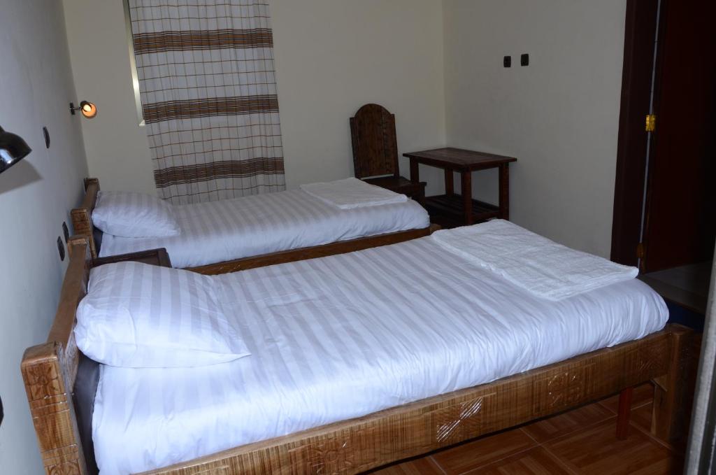 two twin beds in a room with a mirror at Selam Guest House in Lalibela