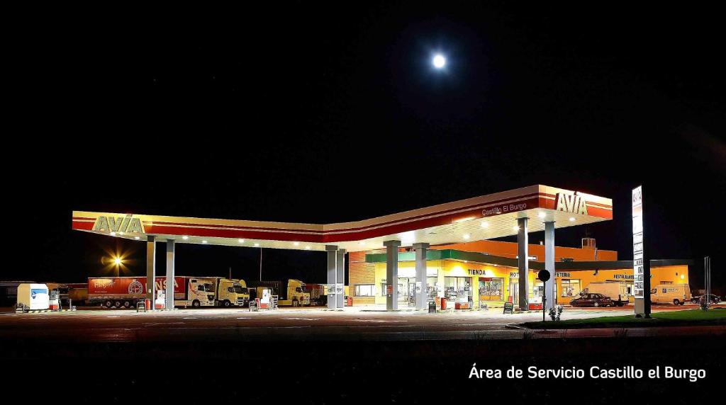 un distributore di benzina di notte con la luna sopra di esso di Hotel Castillo El Burgo a El Burgo Ranero