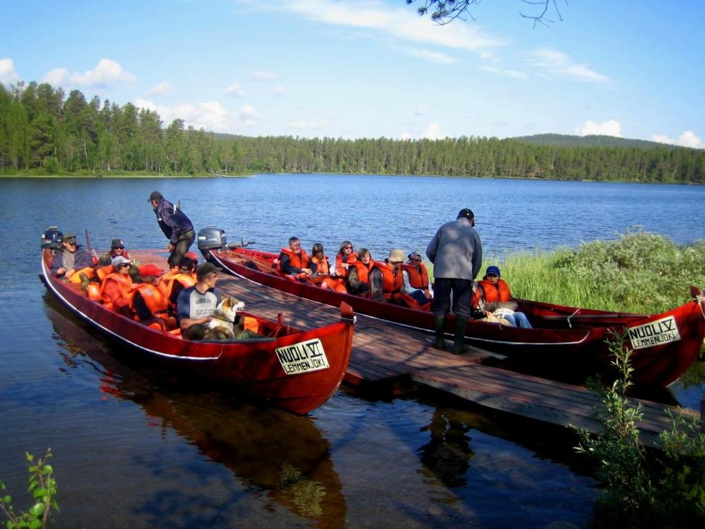 um grupo de pessoas em barcos em um lago em Ahkun Tupa em Lemmenjoki