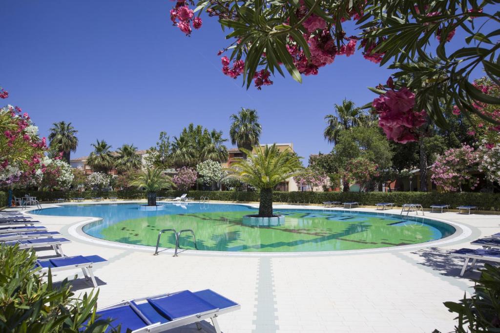 een zwembad met stoelen en bomen in een resort bij Residence Oasi Anfiteatro in Porto Ottiolu
