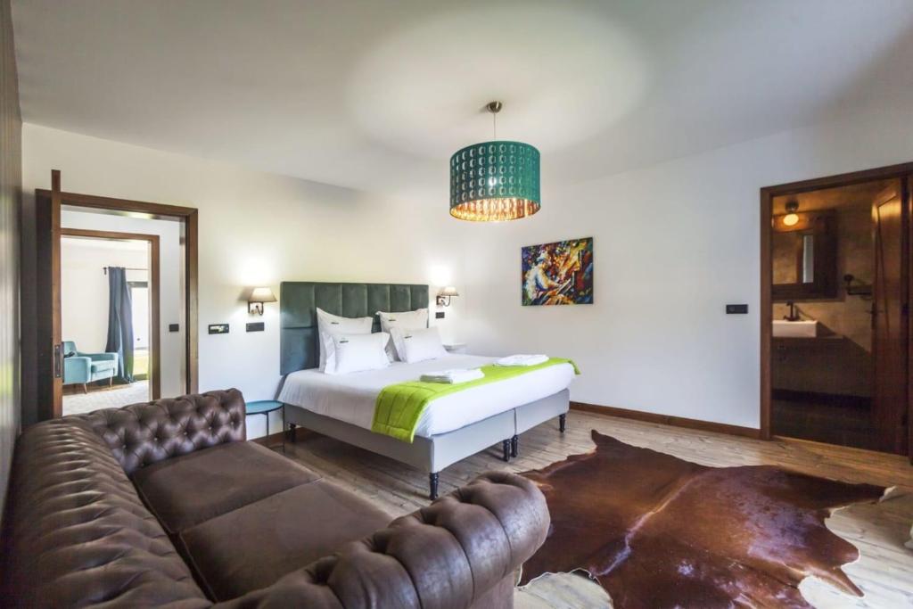 a bedroom with a bed and a couch at Quinta da Morgadia - Private Ocean View Estate in Feteiras