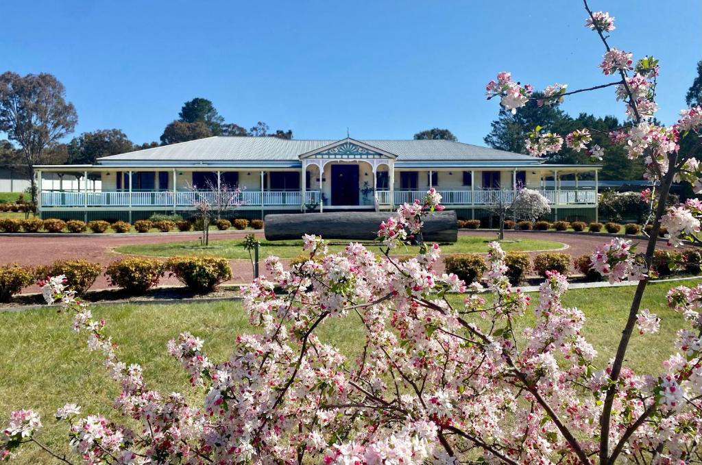 ein Haus mit rosa Blumen davor in der Unterkunft Loggers Rest B&B in Stanthorpe