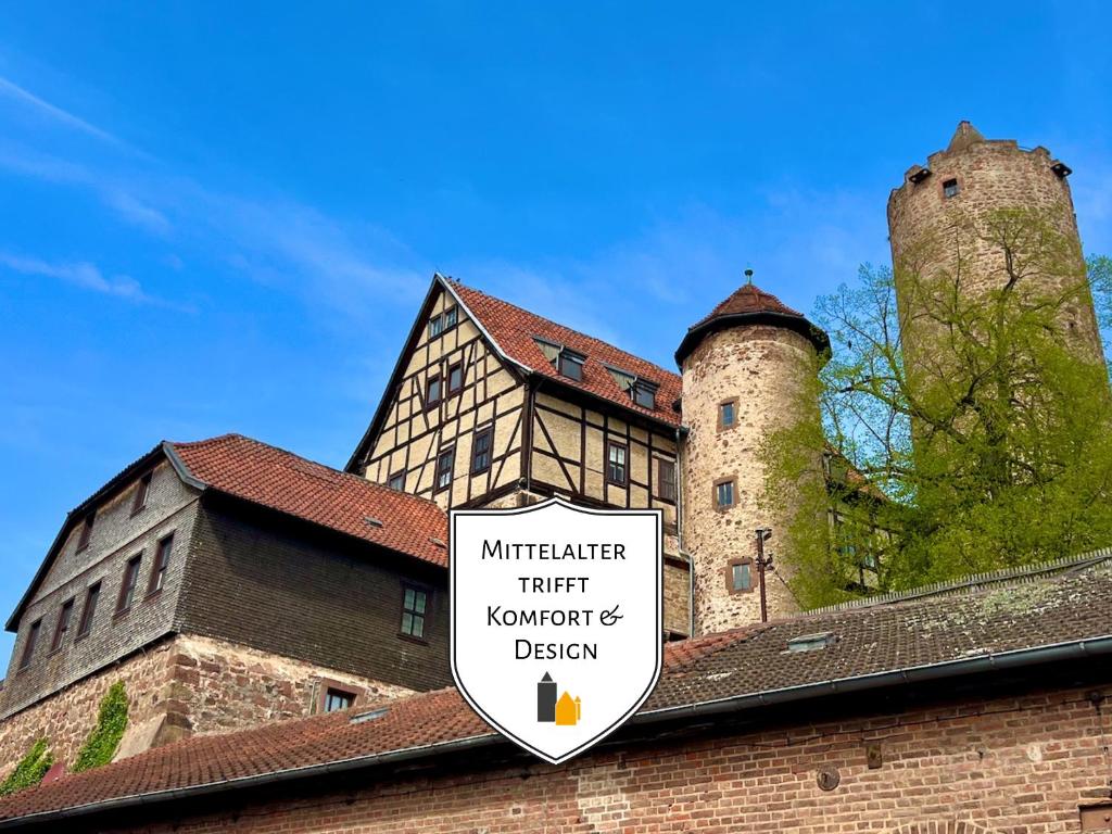 a sign on the roof of a building with two towers at Amalias Burgwohnung - stilvolles Apartment mit Aufzug & Garten in der Hinterburg Schlitz - 2 Schlafzimmer, Parkplatz, Historisches Flair für Paare & Ruhesuchende in Schlitz