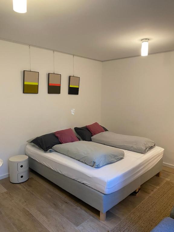 a bed in a room with paintings on the wall at Helle Souterrainwohnung mit Komfort in Munich