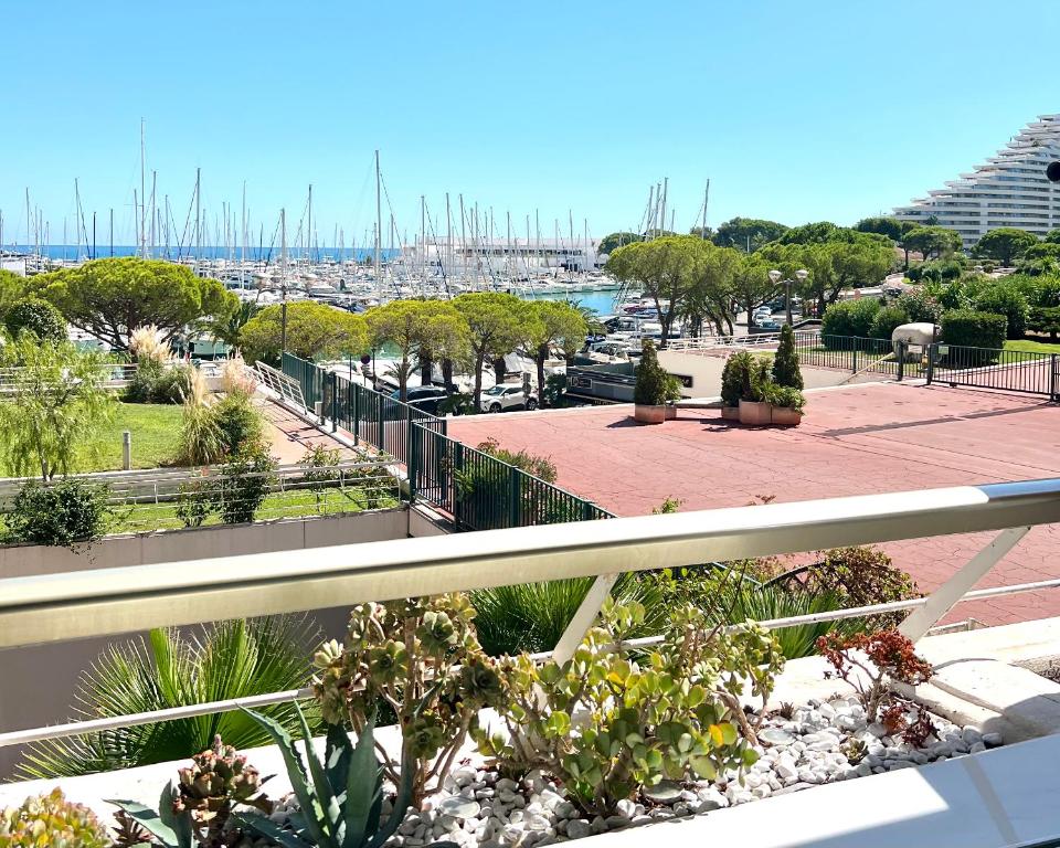 a balcony with plants and a view of a harbor at STUDIO-PORT-MARINA, Parking privé, climatisé au "DUCAL" in Villeneuve-Loubet