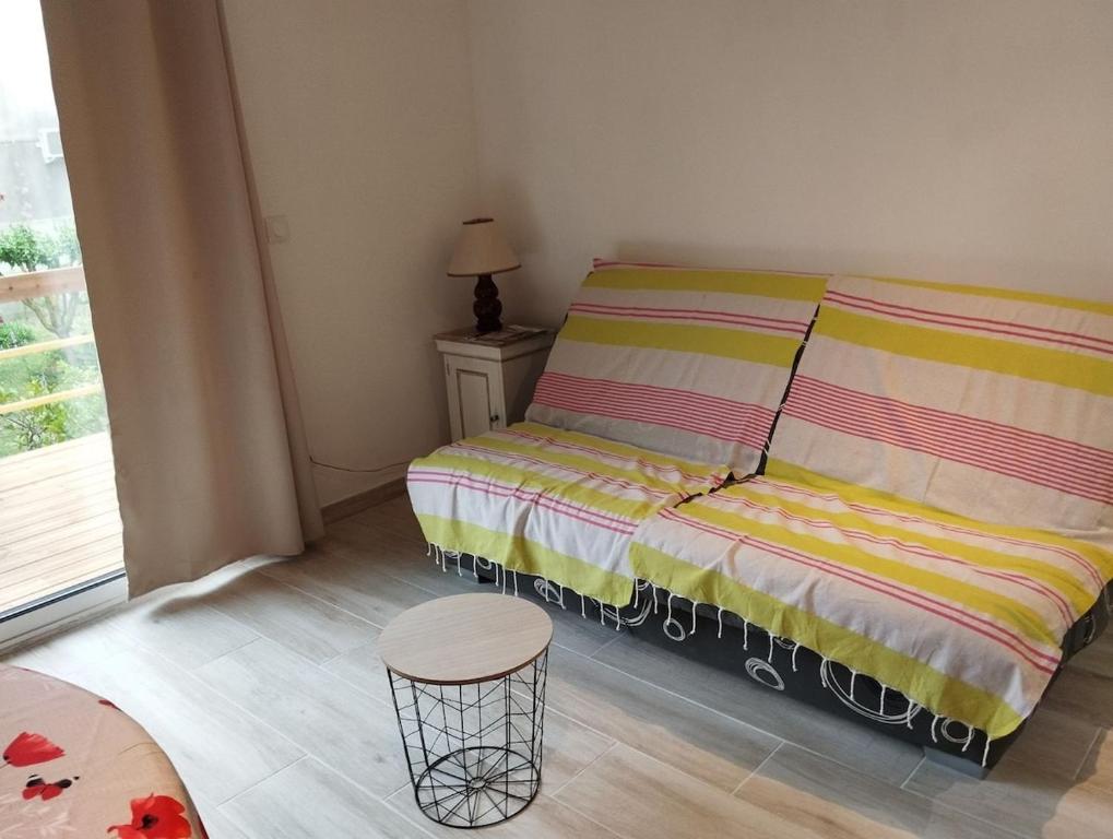a small bedroom with a bed and a stool at Entre Terre et Camargue- Studio de Charme in Le Cailar