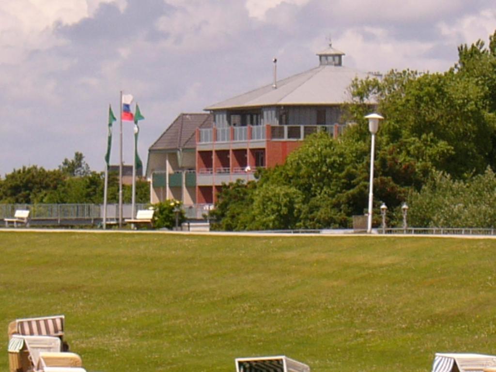a large building with a green field in front of it at Haus Nordstrand Möwenweg 22 in Büsum