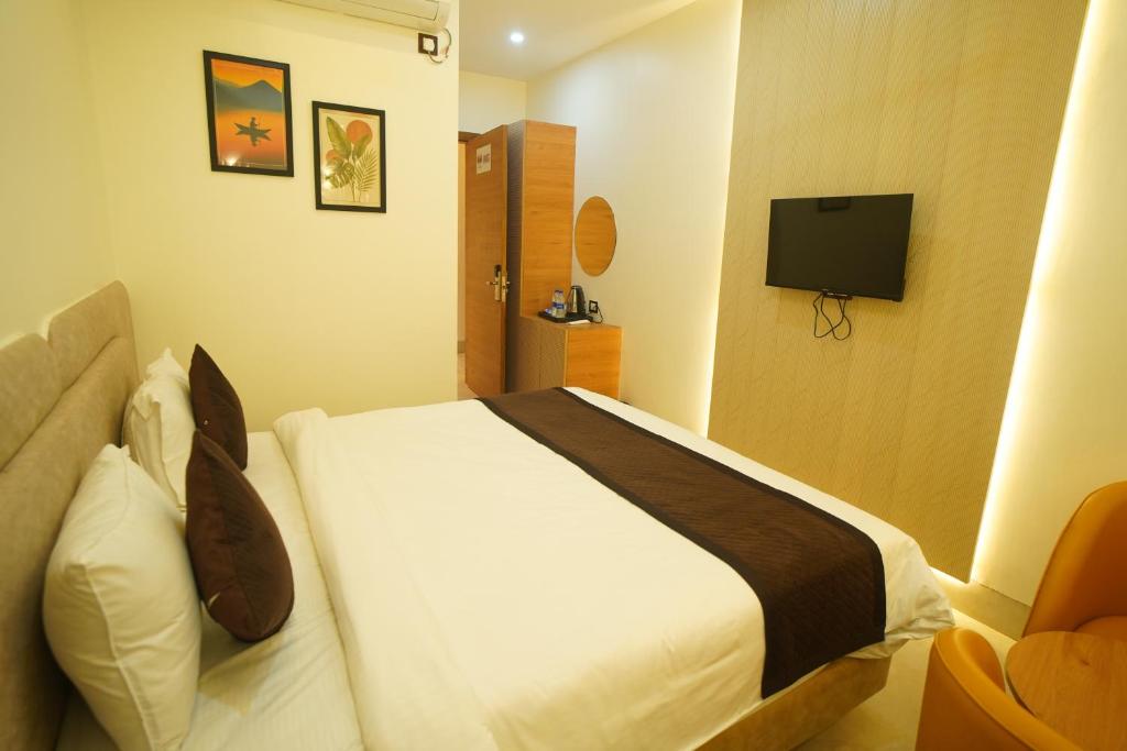 a bedroom with a bed and a television in it at Shri Radha Krishnam in Barsāna