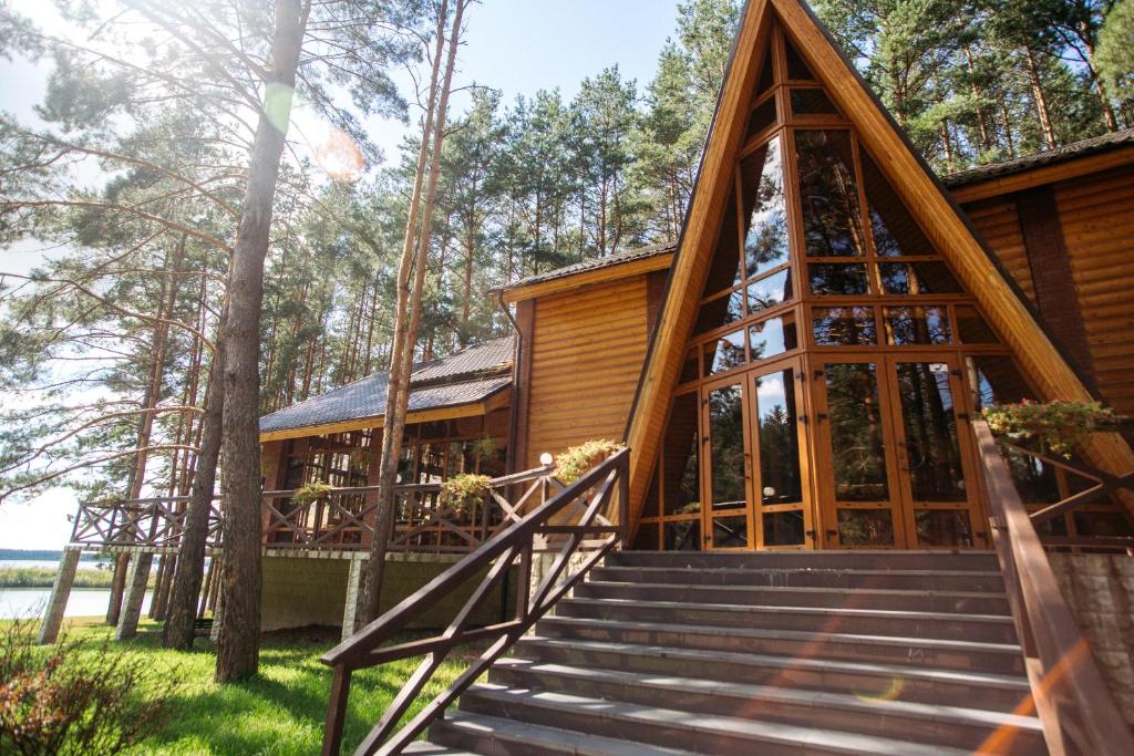 a log cabin with stairs leading up to it at Park Hotel Borvikha in Pilichki