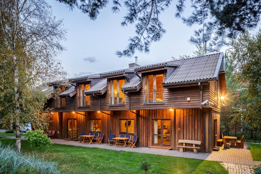 una casa de madera con paneles solares. en Vila Ambasada, en Šventoji