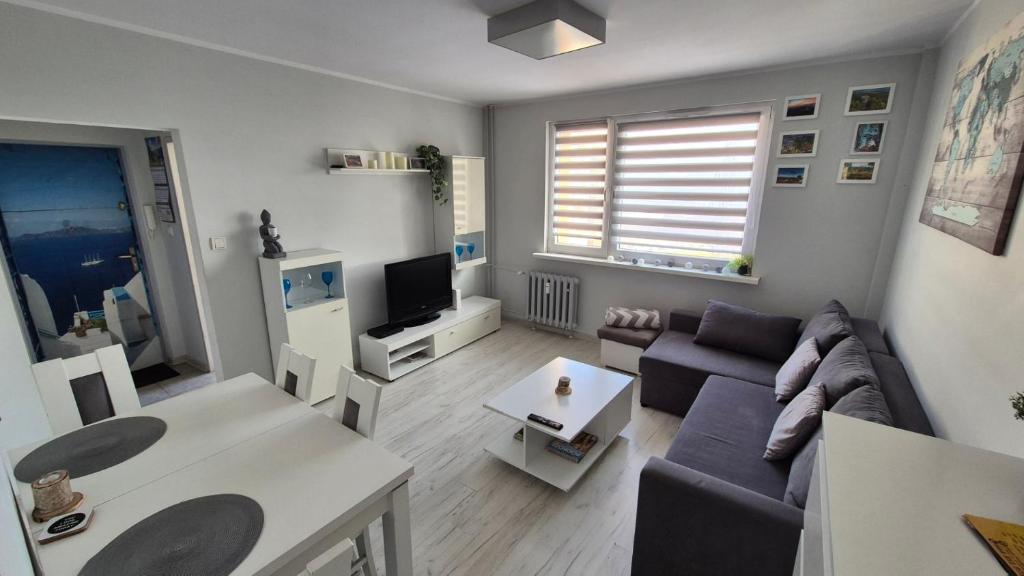 a living room with a couch and a tv at Apartament WAGABUNDA in Wałbrzych