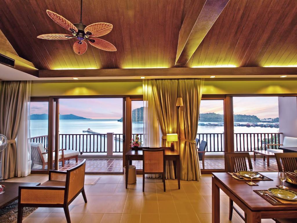 a living room with a ceiling fan and a view of the ocean at The Sea View Residence in Ban Bang Bao
