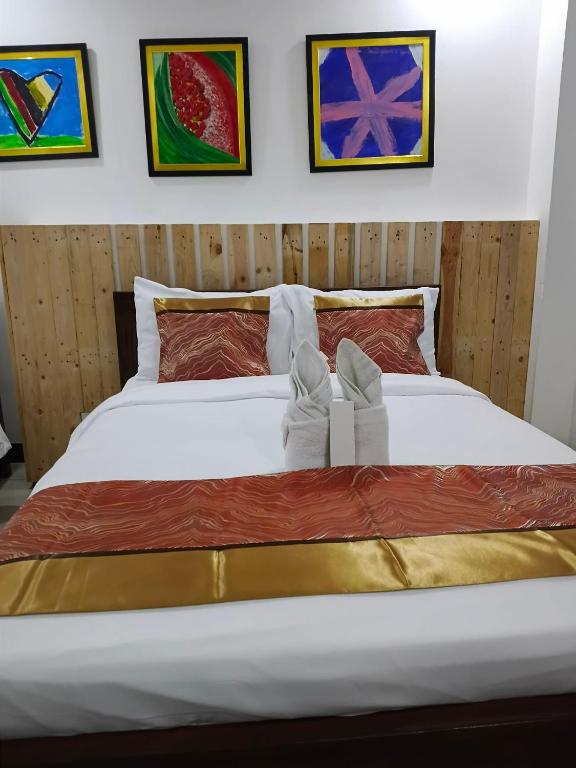 ein Bett mit einem Paar Schuhen darauf in der Unterkunft D'Builders Rooms Hotel in Sampong