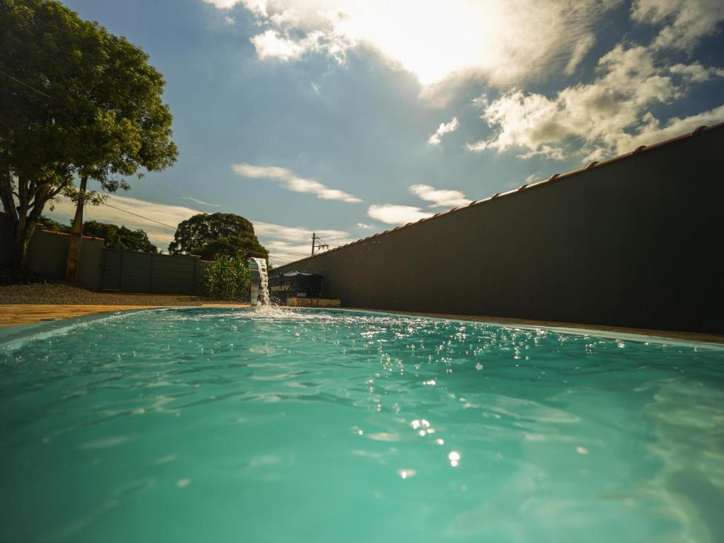 a swimming pool with a fountain in a yard at Recanto do entardecer in Socorro