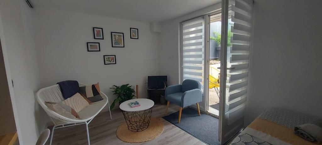 een woonkamer met een stoel en een tafel bij Studio cosy in Écouflant