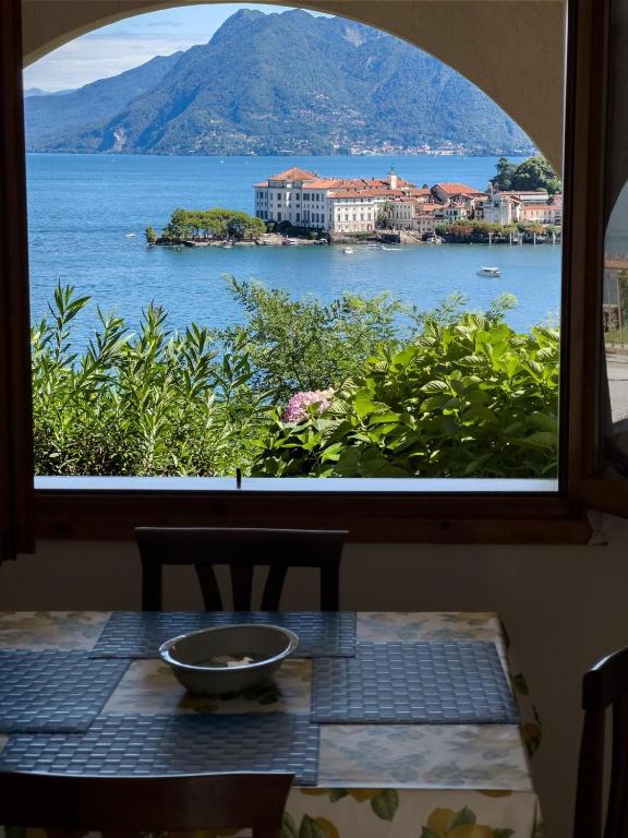 a table with a view of the ocean from a window at VistaBellaBorromeoFlat in Baveno