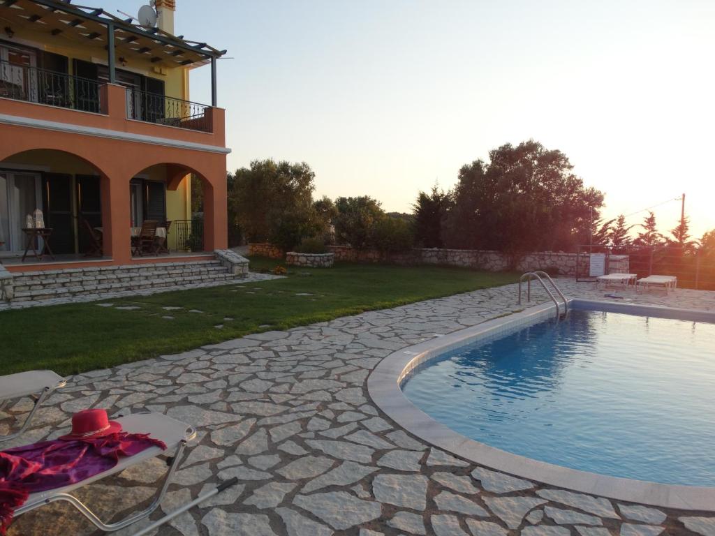 a swimming pool in a yard next to a house at Villa Stamata in Tsoukaladhes