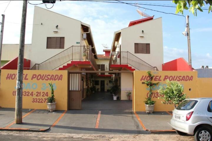 a building with a car parked in front of it at Hotel Pousada João 3.16 in Barretos