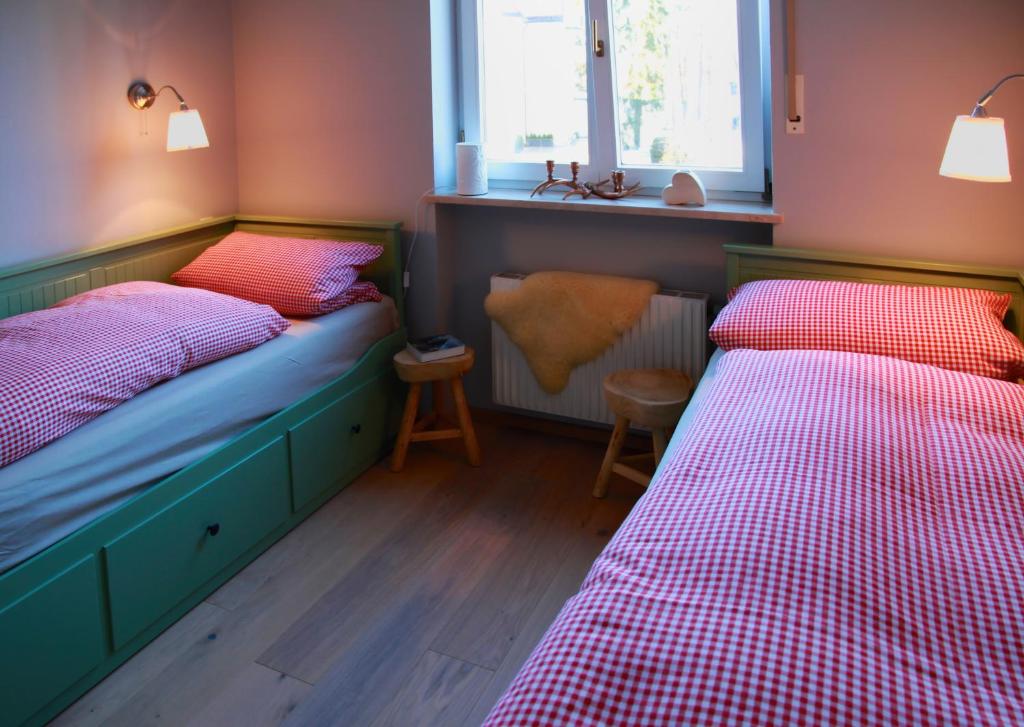 2 Betten in einem Zimmer mit rosa und blau in der Unterkunft AlexaFerien in Bad Tölz