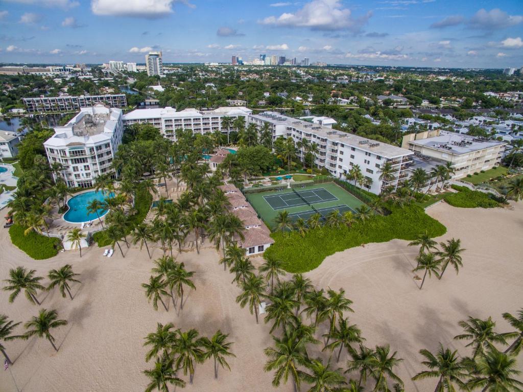 una vista aérea de un complejo con una pista de tenis y palmeras en The Lago Mar Beach Resort and Club, en Fort Lauderdale