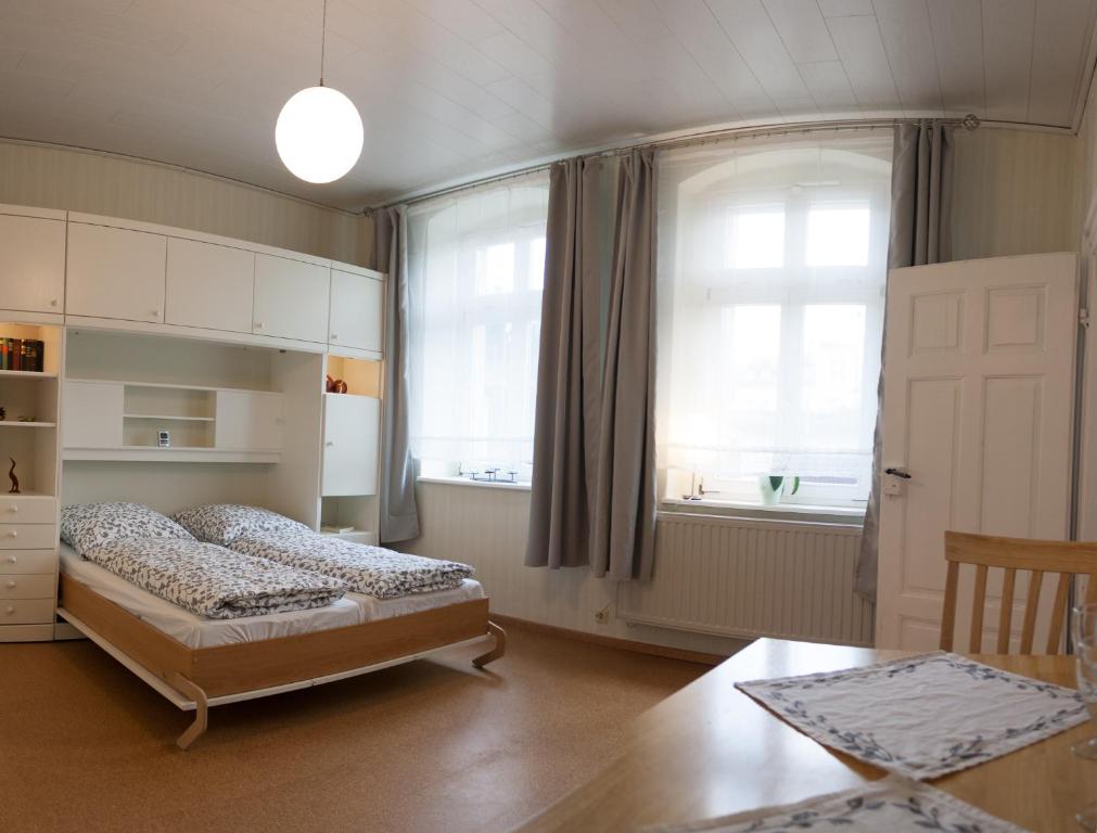 Schlafzimmer mit einem Bett, einem Fenster und einem Tisch in der Unterkunft Wohnen im Denkmal in Quedlinburg