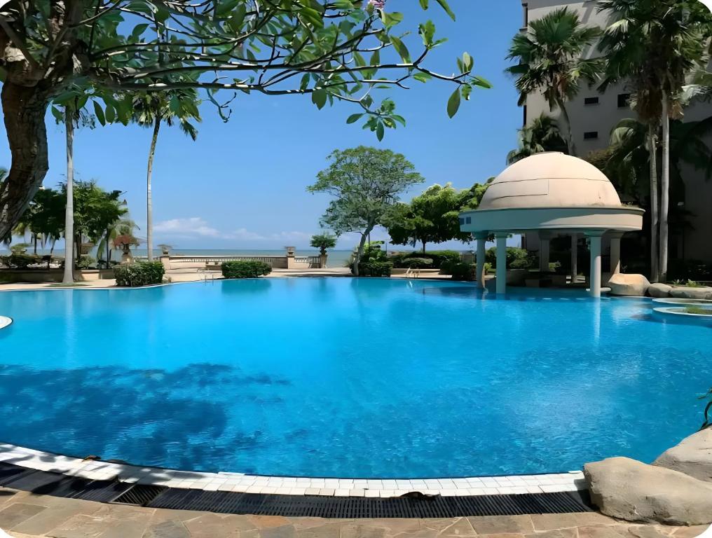 a large swimming pool with a gazebo next to a building at 2BR Seaview Condo with Balcony, Riviera Bay Resort Melaka in Malacca